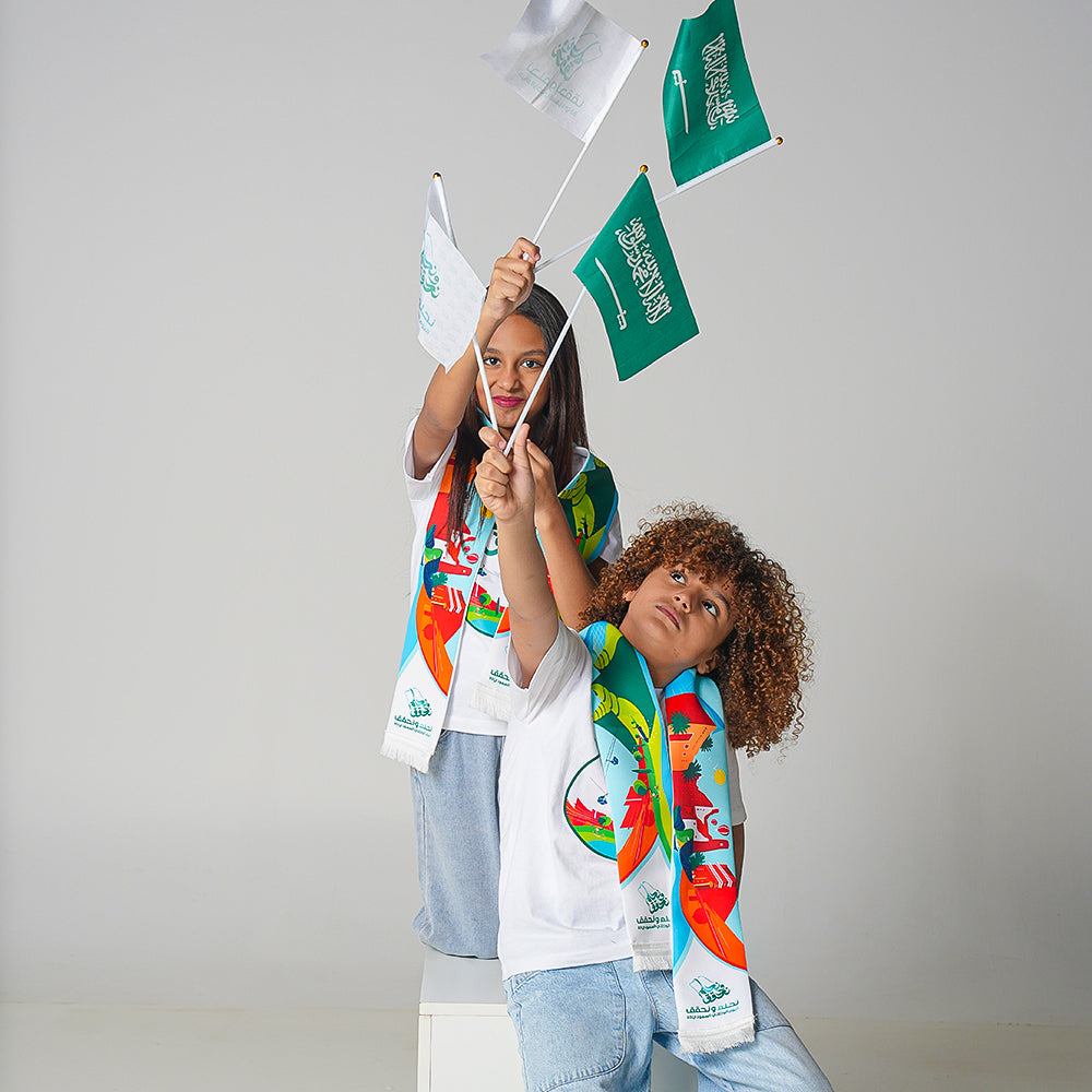 بكج اليوم الوطني السعودي 93 للاطفال ( شال + تيشيرت + ورق ألوان + ستيكرات+ علم يد سعودي وعلم يد بشعار نحلم ونحقق)