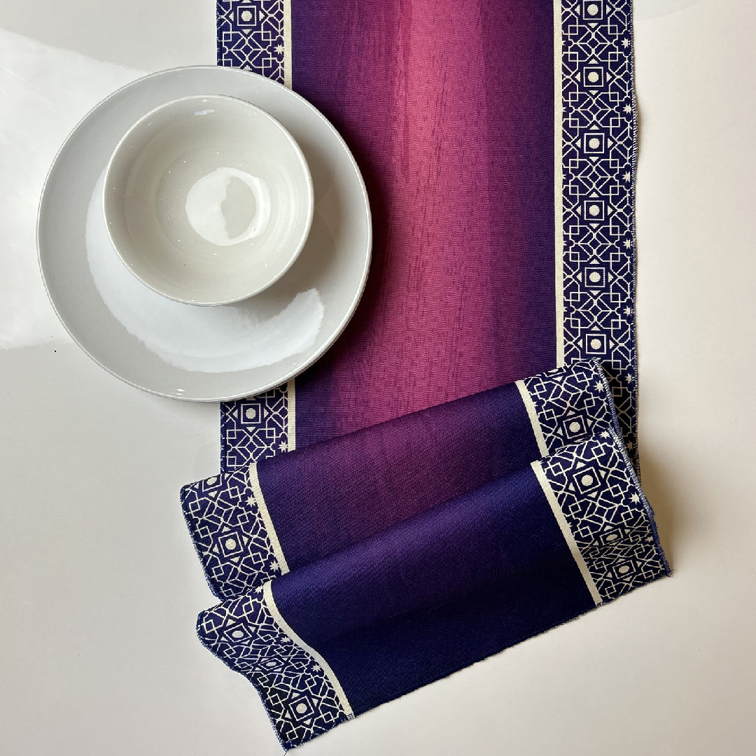 white tableware on a folded purple table runner