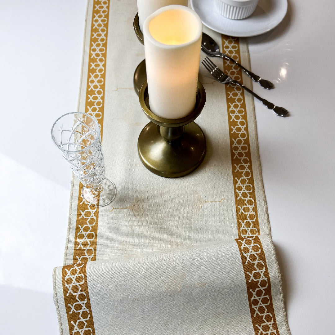 Candle holder and tableware on a beige table runner
