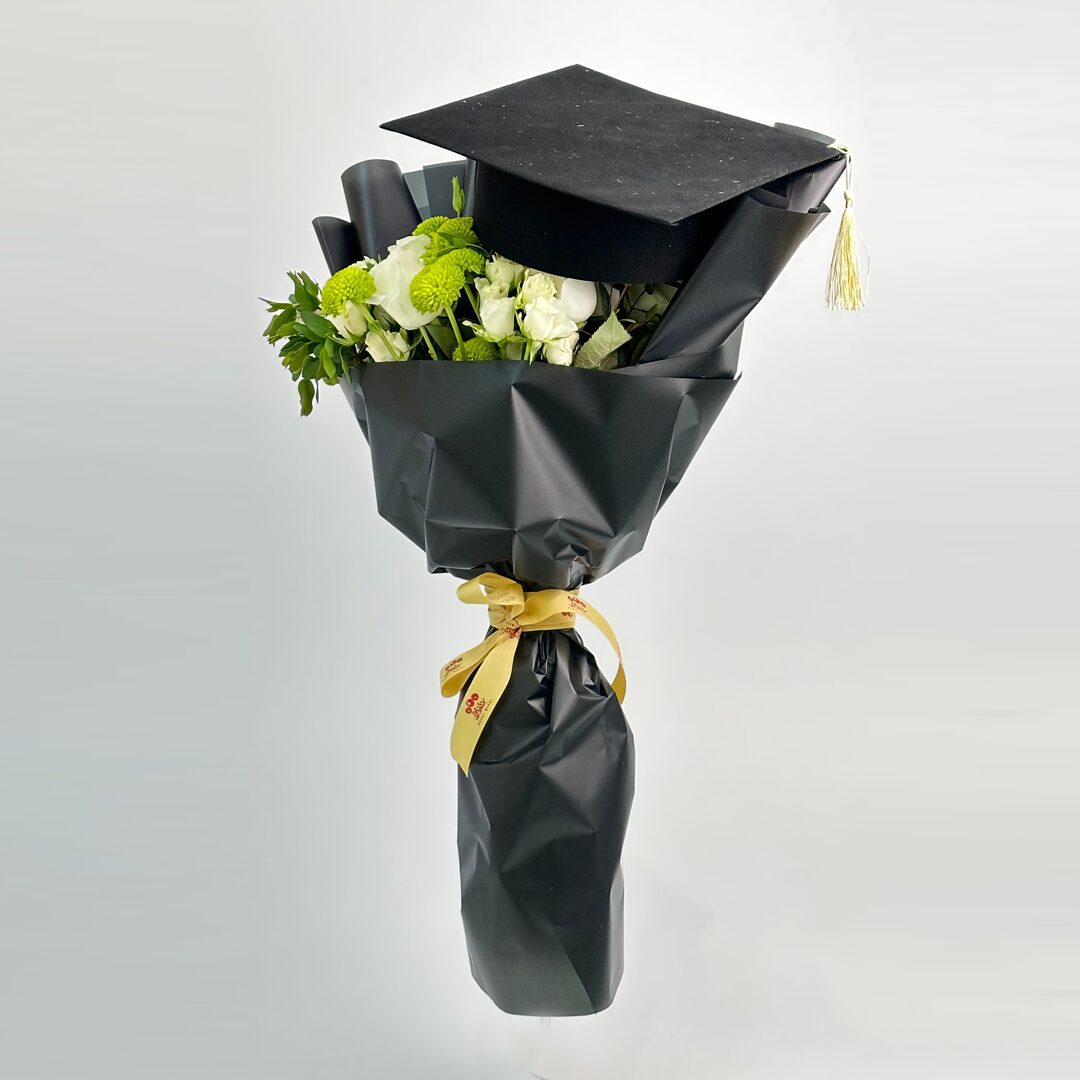 Flowers bouquet with graduation cap and cake