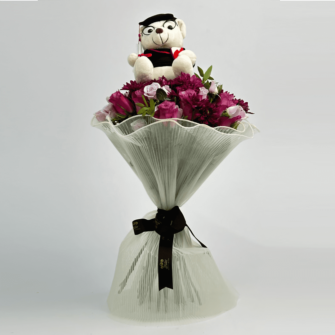 A bouquet of roses with a teddy bear