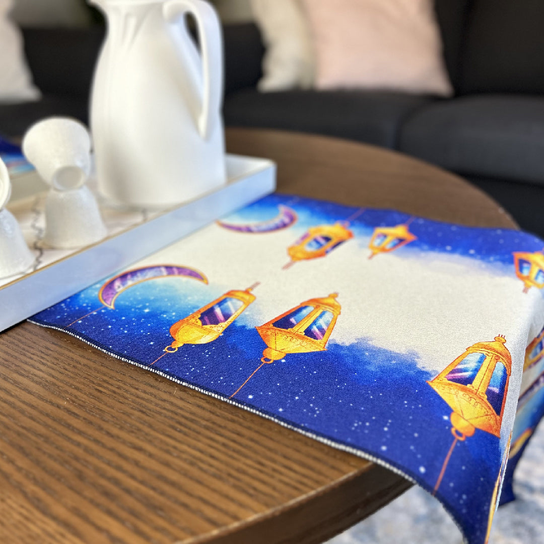 blue table runner with golden lantern print with a tea set on a wooden table